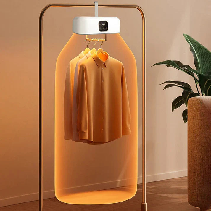 Clothing dryer with a shirt inside, placed against a neutral wall with a plant in the background.