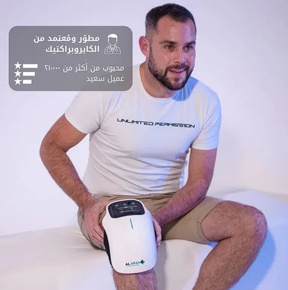 Man holding a white electronic device with Arabic text and branding on a light background