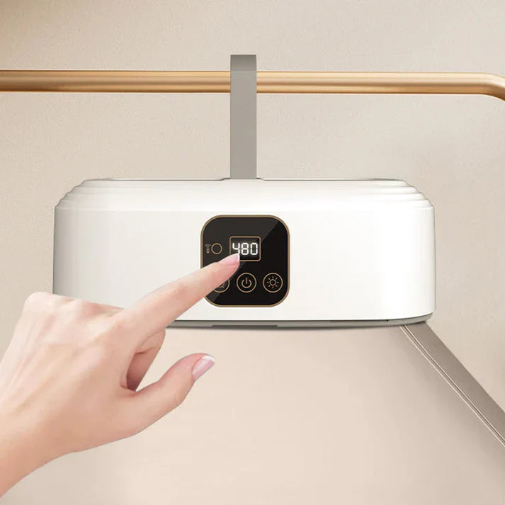 Hand pressing a button on a white electronic device with a digital display against a beige background